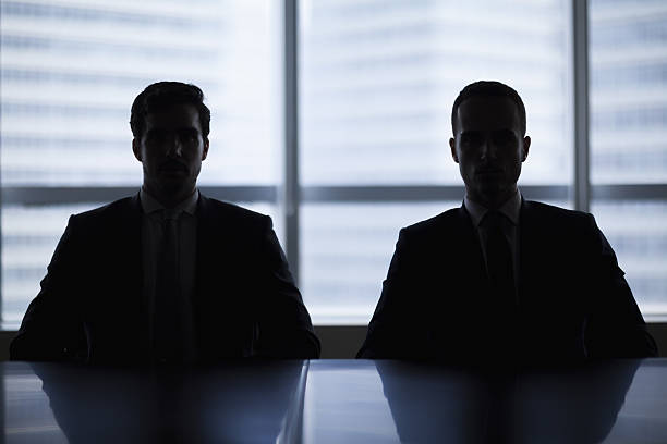 silhouette paire d’hommes d’affaires dans la salle de réunion - mauvais présage photos et images de collection