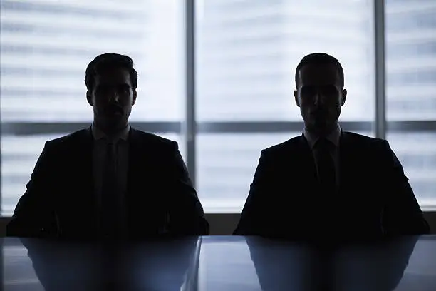 Photo of Silhouette pair of businessmen in meeting room