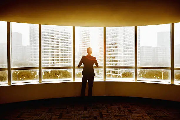 Photo of Businessman looking at city in modern office