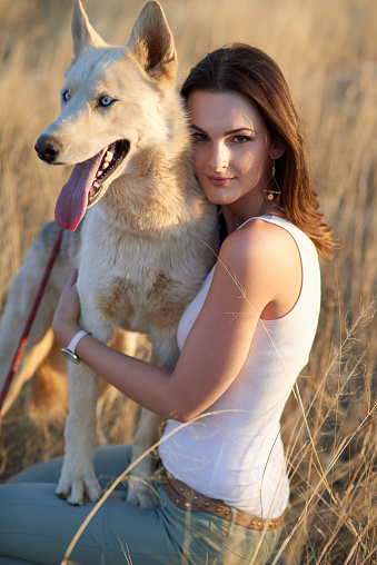 Portrait of an attractive young woman bonding with her dog outdoors