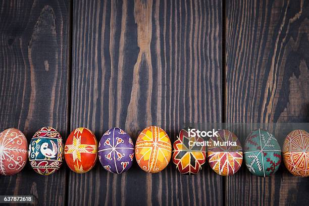 Huevos De Pascua En Una Fila Sobre Fondo De Madera Oscura Foto de stock y más banco de imágenes de Cultura ucraniana