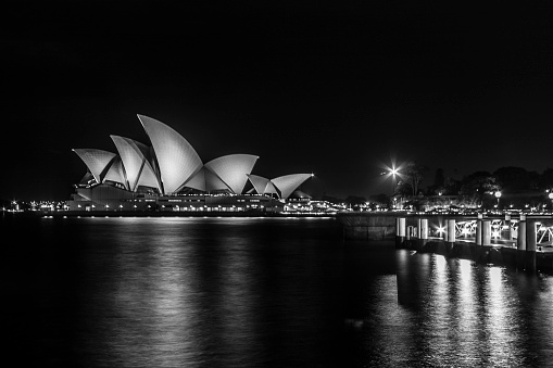 Sydney, Australia - January 11, 2009: Side view of Opera House from promenade at night. The Opera House is seen across the water of Sydney Harbour. It is a symbol of Australia. Sydney Opera House is the most famous building of Australia.