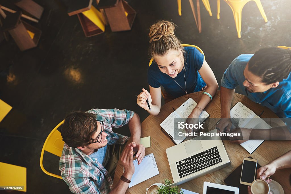 We have everything we need to pass High angle shot of a group of students studying in a coffee shop University Student Stock Photo
