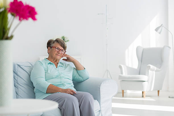 istock Senior woman sitting on sofa 637874628