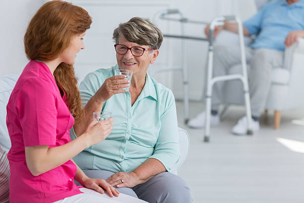 istock Nurse drinking water with senior woman 637874648
