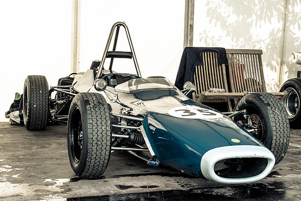 West Sussex, England - September 16, 2011:  Members of the public wearing period clothing inspect the racing cars in the paddock at the Goodwood Revival, West Sussex, England.