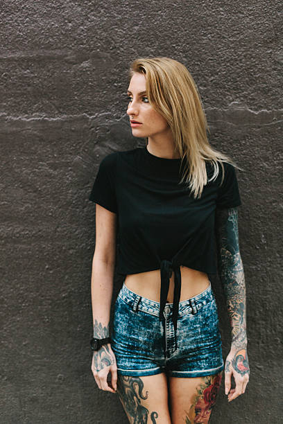 istock Tattooed Woman Leaning on a Dark Wall 637878078