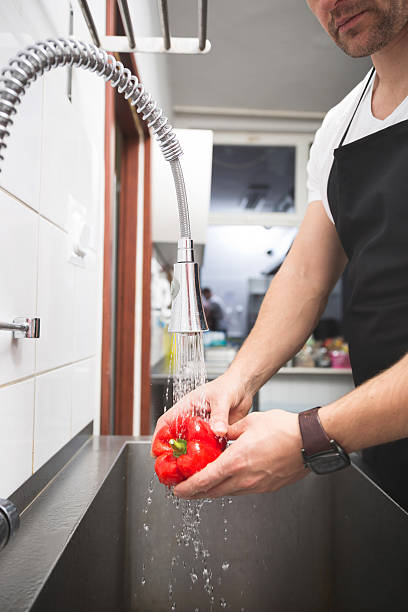 istock Chef washing pepper in the sink 637878386