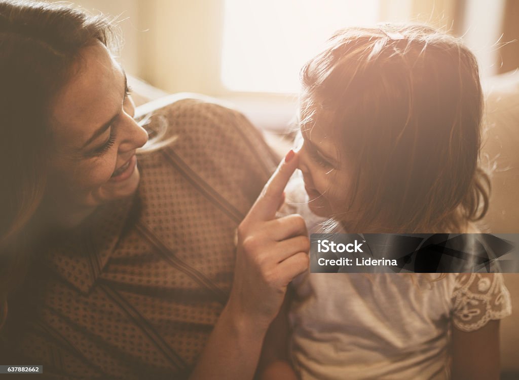 Mother Daughter Love. Mother and daughter are having fun at home. Mother touching daughter's nose. Mother Stock Photo