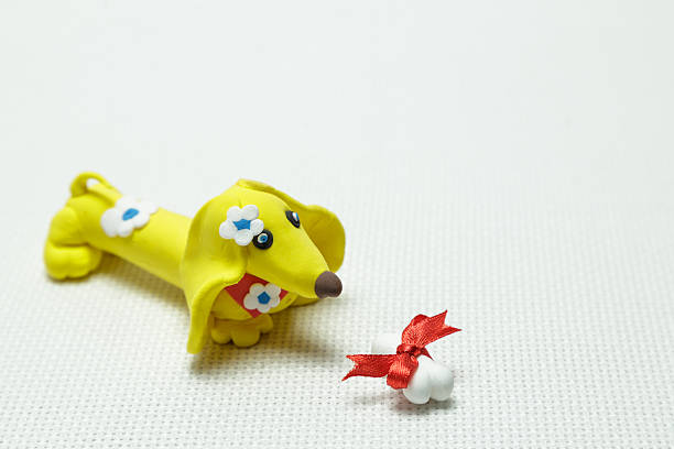 istock Dog and bone from plasticine tied up by a band 637882762