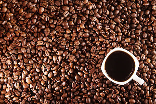 istock Coffee background. Coffee beans and cup of coffee over table. 637884562