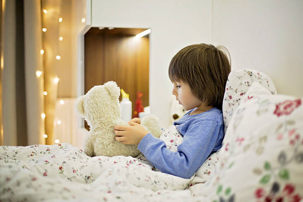 istock Cute sick child, boy, staying in bed, playing with teddy 637884818
