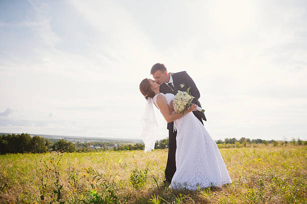 istock couple bride and groom on field background 637887216