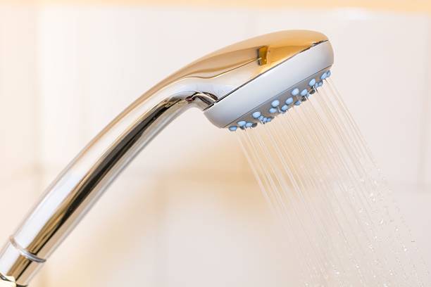 istock Close up of a shower head with sprinkling water 637888038