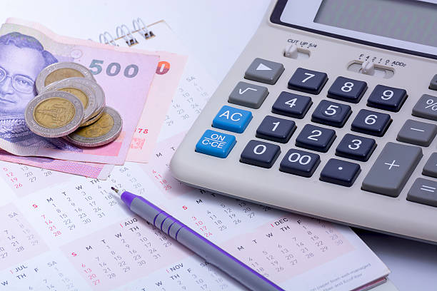 istock Old dusty ball pen on calculator with stack coins background 637889848