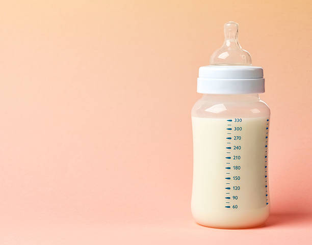 baby milk bottle baby milk bottle on pink background milk bottle stock pictures, royalty-free photos & images