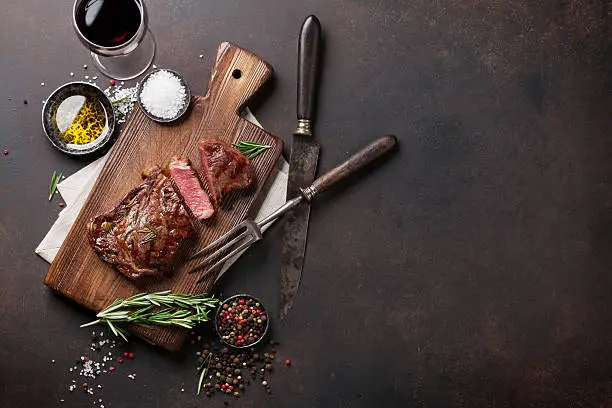 Photo of Grilled ribeye beef steak with red wine, herbs and spices