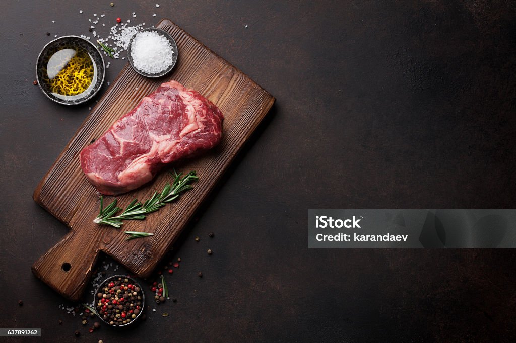 Raw ribeye beef steak cooking with ingredients Raw ribeye beef steak cooking with ingredients. Top view with copy space Meat Stock Photo