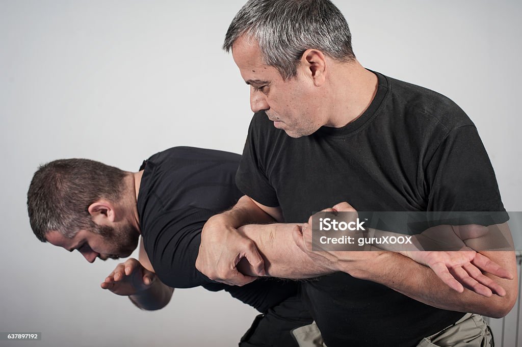 Kapap instructor demonstrates arm bar techniques Kapap instructor demonstrates arm bar techniques with his student Self-Defense Stock Photo