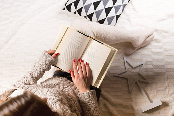 istock Woman relaxing with a book at her home 637898950