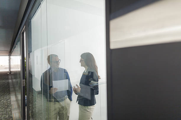 Pair of colleagues talking together in office
