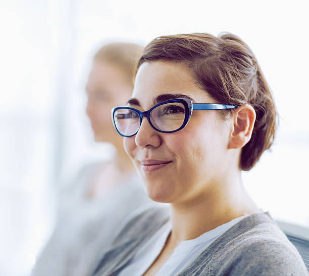 woman smiling in office meeting - onconventioneel leiderschap stockfoto's en -beelden