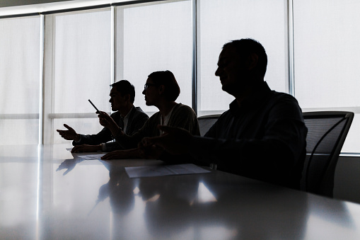 Silueta de empresarios negociando en la mesa de reuniones photo