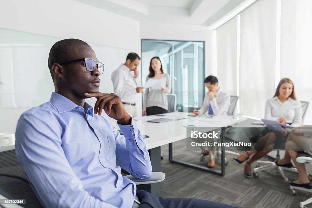 Businessman thinking during meeting in office Shy Stock Photo