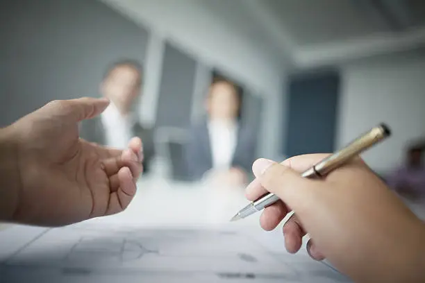 Photo of Close-up of hands gesturing during business meeting in office