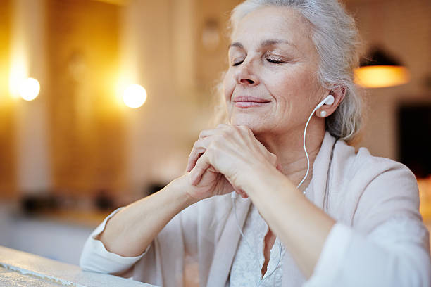 Music for relax Mature woman with earphones listening to music happy people audio stock pictures, royalty-free photos & images