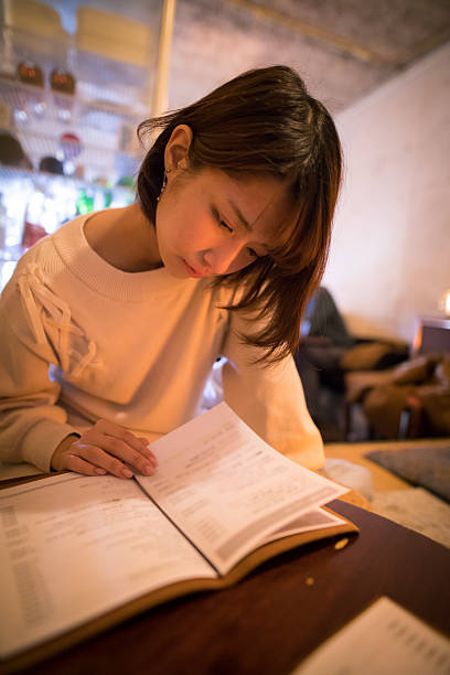 Young woman looking at menu in cafe