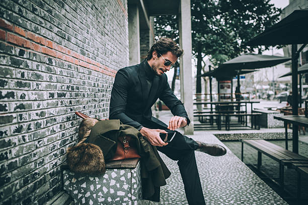 элегантный человек, сидящий на скамейке - day expressing positivity clothing desire стоковые фото и изображения