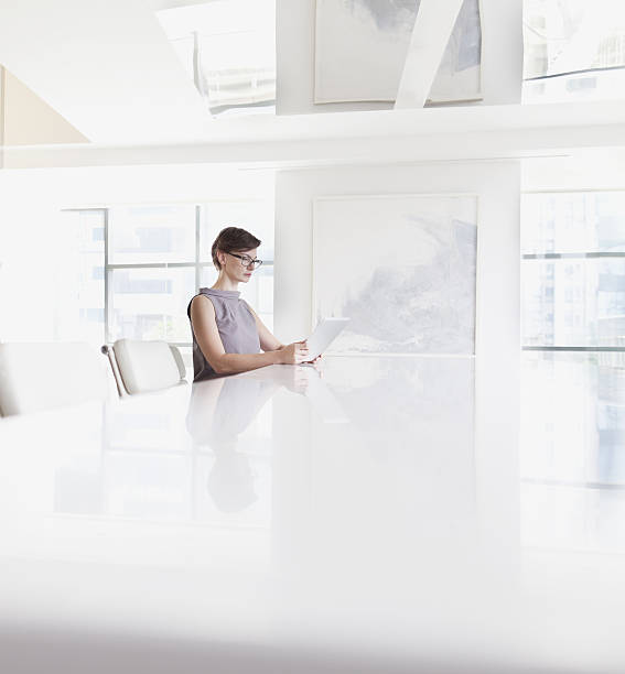 femme assise à l’aide d’une tablette informatique dans la chambre - surexposition photos et images de collection