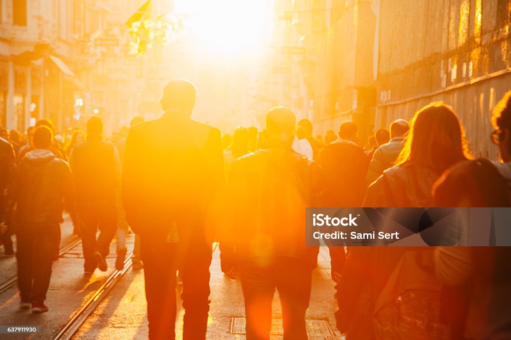 Crowd on street in bright lens flare Crowded pedestrian walking on Istiklal street on sunny day with sunflare in Taksim, Beyoğlu, Istanbul, Turkey People Stock Photo