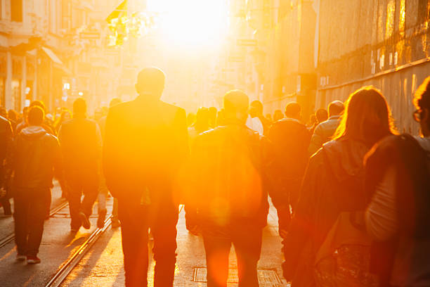 Crowd on street in bright lens flare Crowded pedestrian walking on Istiklal street on sunny day with sunflare in Taksim, Beyoğlu, Istanbul, Turkey orange sunset stock pictures, royalty-free photos & images