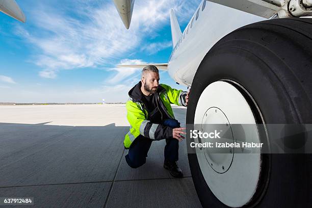 Airport Worker Checking Tires Stock Photo - Download Image Now - Airport, Airplane, Occupation