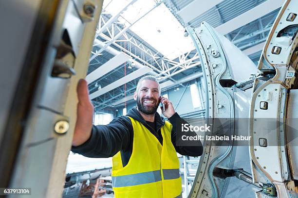 Aircraft Engineer Talking On Smart Phone In A Hangar Stock Photo - Download Image Now