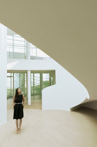 Woman looking at architecture in lobby of building