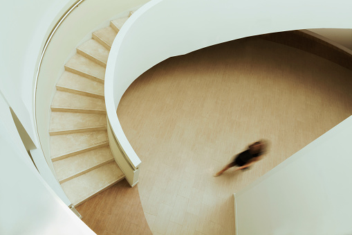 View of blurred person walking towards staircase in building