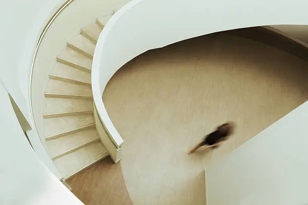 Photo of View of blurred person walking towards staircase in building