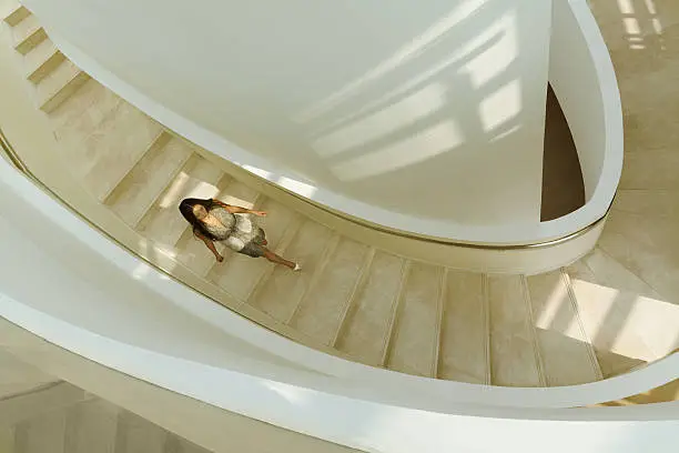 Photo of View of woman descending staircase in modern building