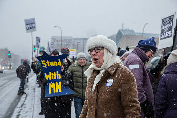 Minneapolis, Minnesota, USA - January 9, 2017: Protestors marched in the snow on Washington Ave outside of Senator Amy Klobuchar’s office in Minneapolis on the national Day Against Denial to demand that climate deniers appointed to public office to rejected.