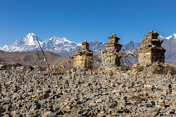 buddhistische chorten über muktinath dorf, dhaulagiri steigt im babkground - muktinath stock-fotos und bilder