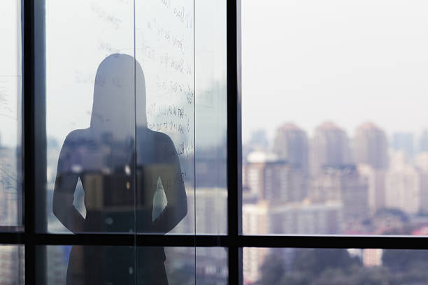 silhouette shadow of woman looking at city from office - holy city imagens e fotografias de stock