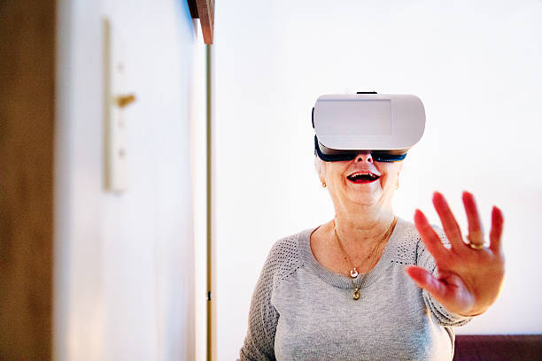 istock Senior woman amazed at using VR helmet 637924298