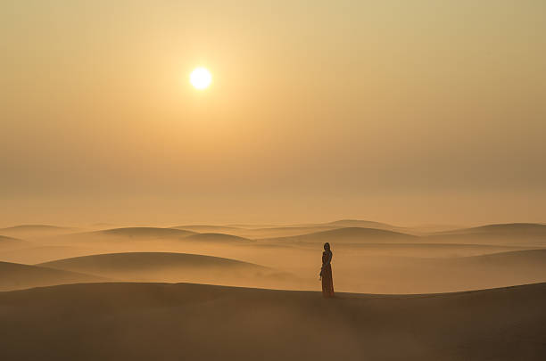 uma mulher em um deserto ao nascer do sol perto de dubai - solitude morning nature rural scene - fotografias e filmes do acervo