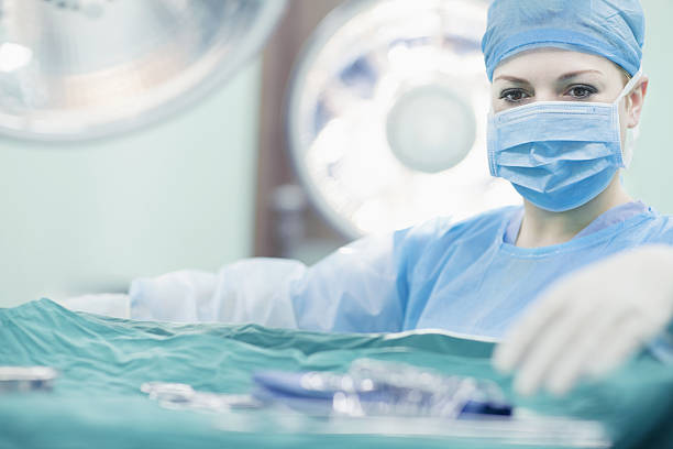 un médecin cherche des outils chirurgicaux dans la salle d’opération de l’hôpital - plateau ustensile photos et images de collection