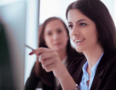 Women looking at computer screen in office