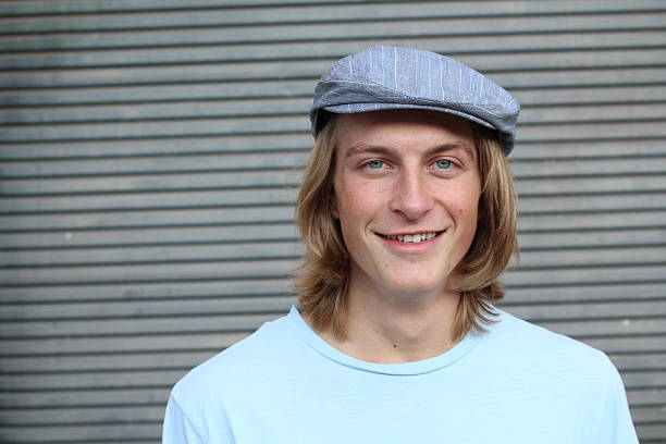 istock Young man wearing news paperboy hat 637927984