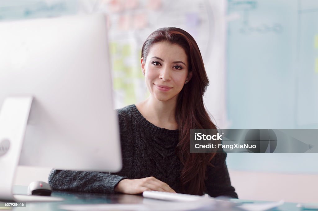 Portrait of woman next to computer in studio office Real Estate Office Stock Photo